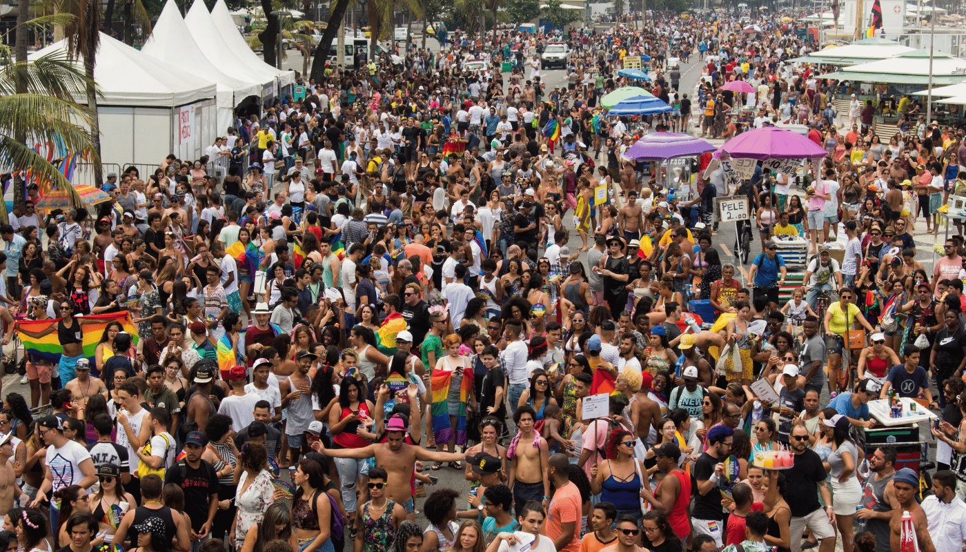 Multidão na Parada do Orgulho LGBTI+ Rio com bandeiras do arco-íris